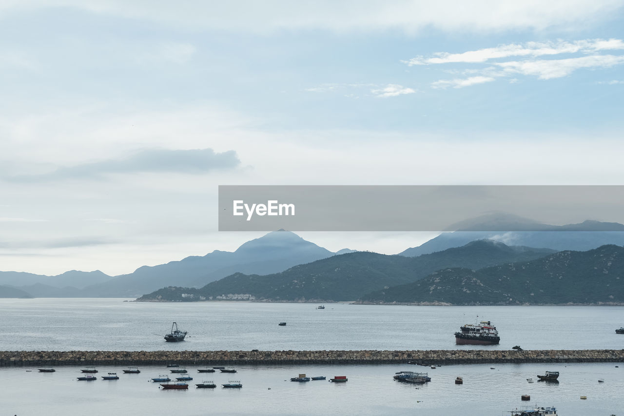 scenic view of sea and mountains against sky