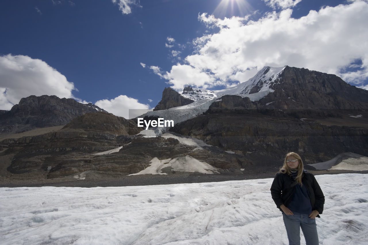 Full length of woman on snowcapped mountains against sky