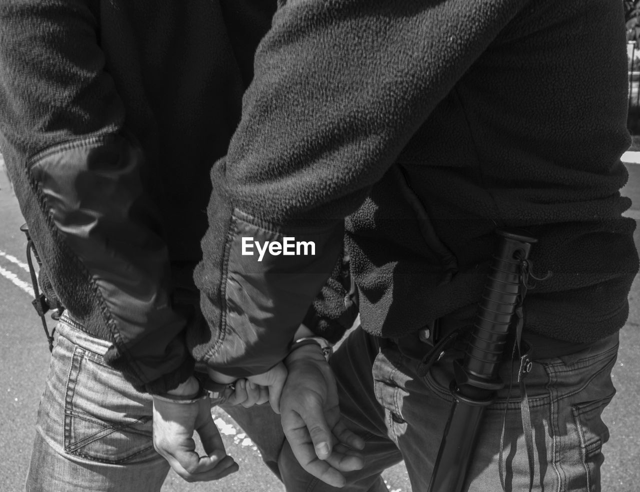 Midsection of policemen with hand cuffs