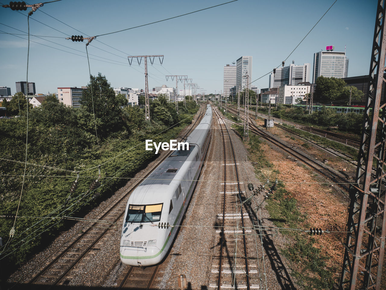 Railroad tracks in city against sky