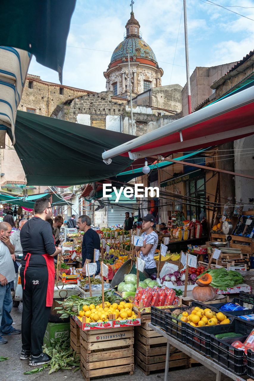 PEOPLE IN MARKET STALL