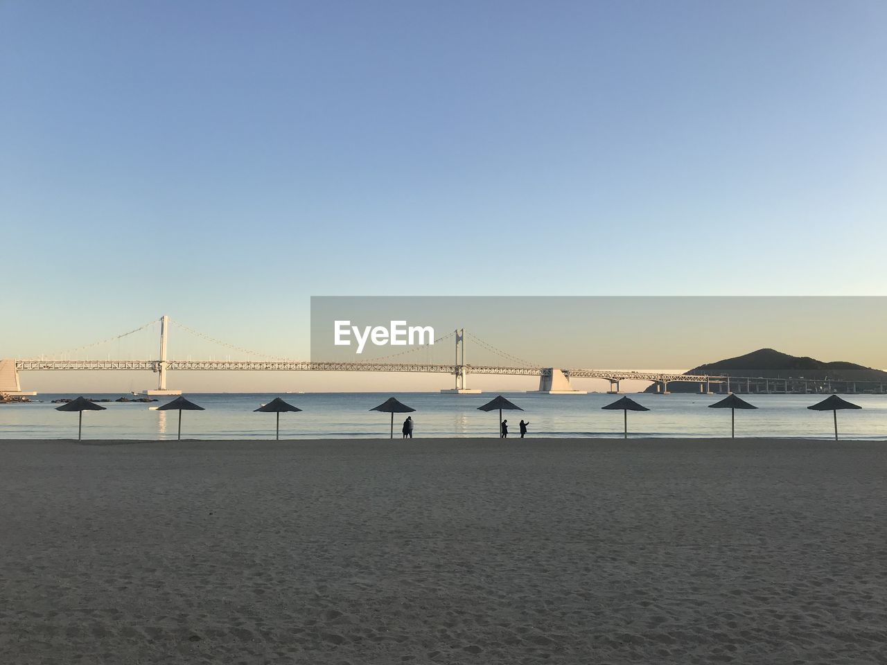 View of suspension bridge over sea against clear sky