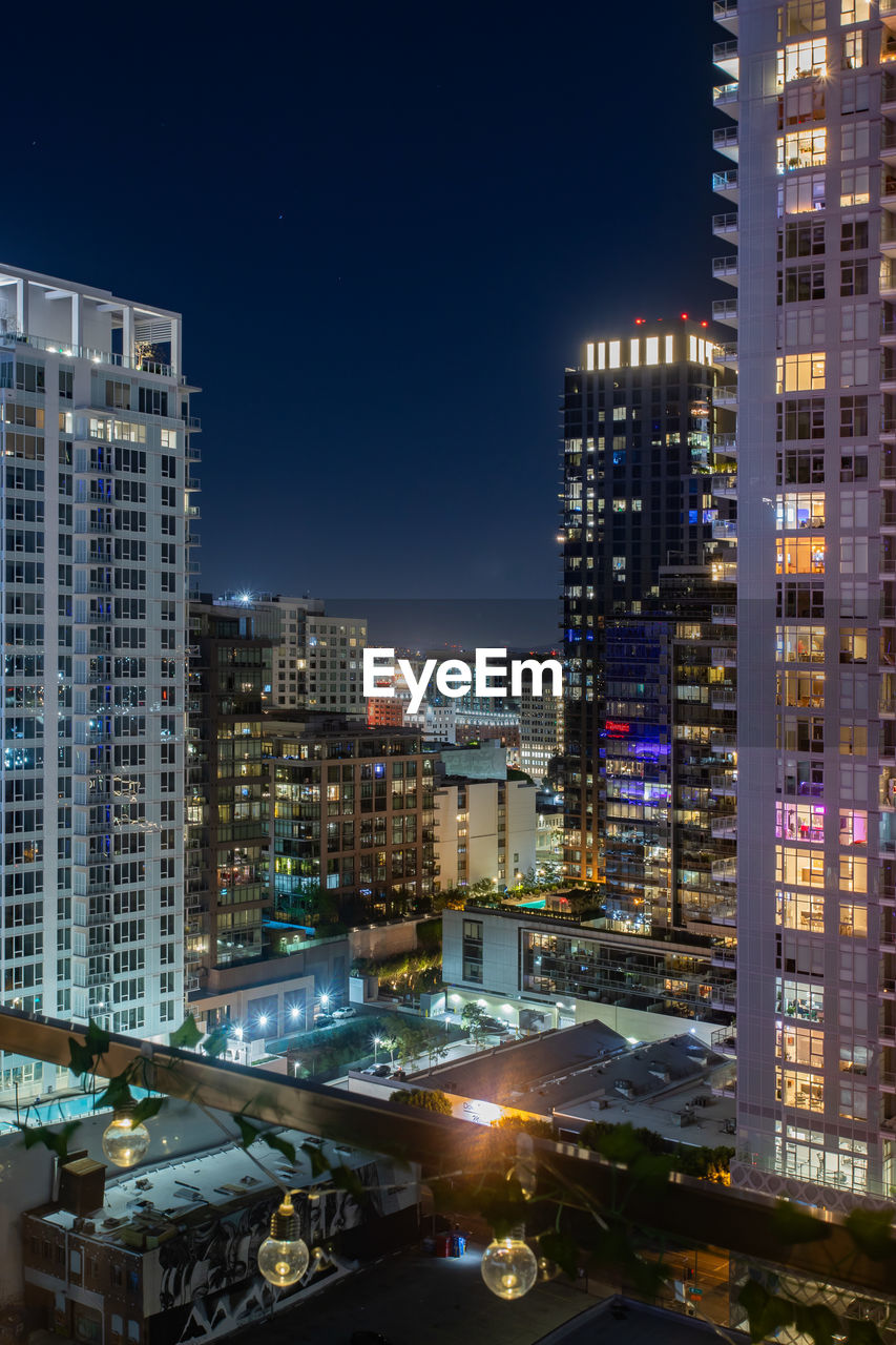 high angle view of illuminated buildings in city at night