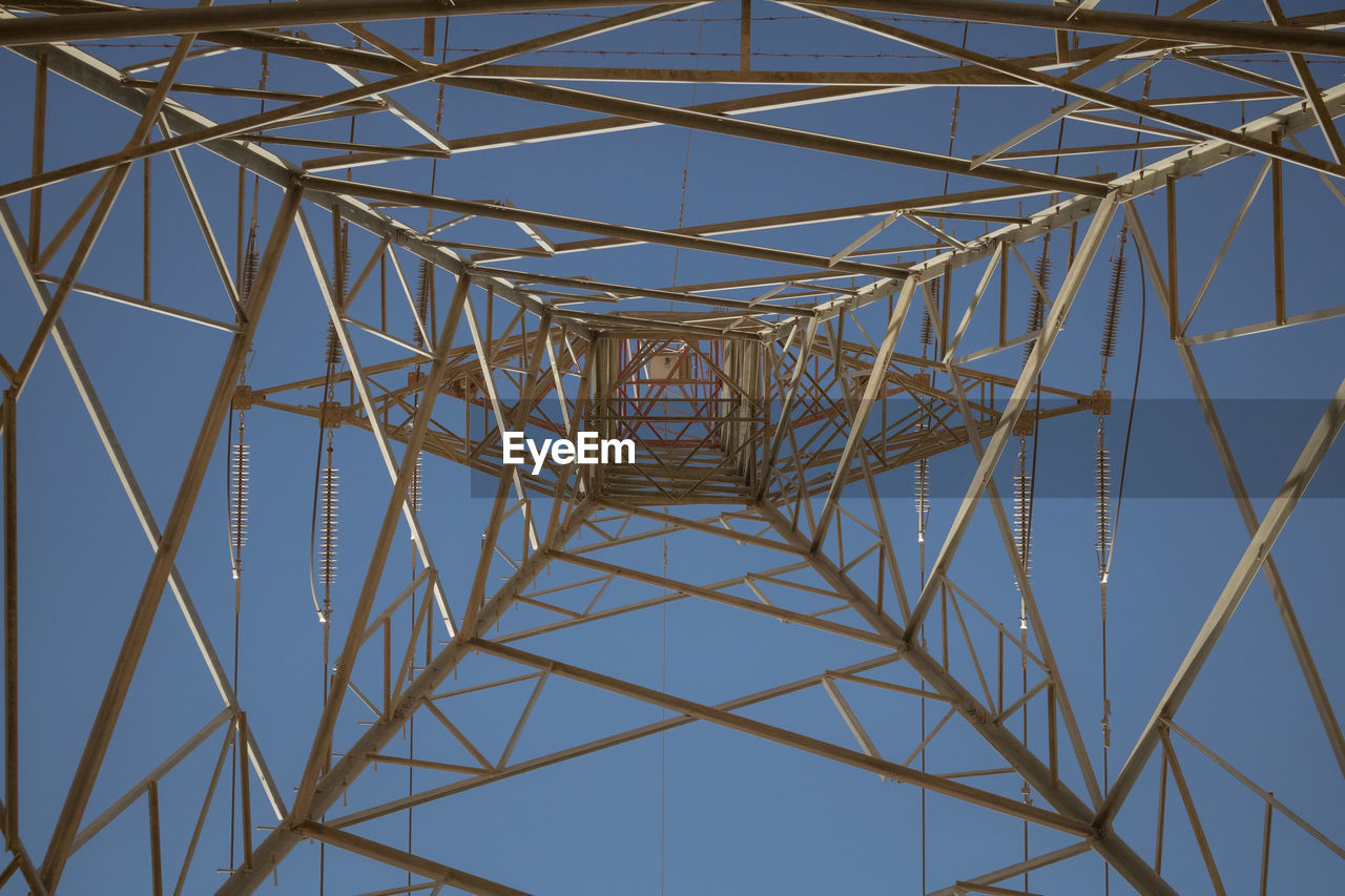 DIRECTLY BELOW SHOT OF ELECTRICITY PYLON AGAINST CLEAR SKY