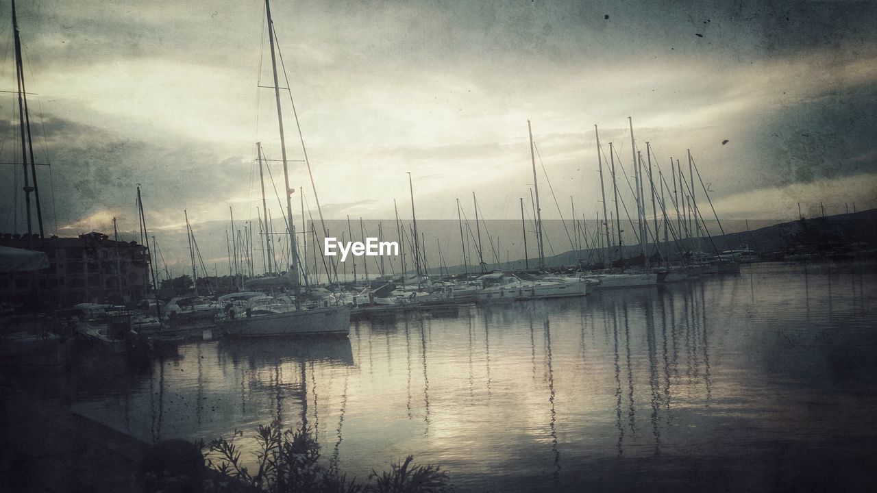 Sailboats moored on lake