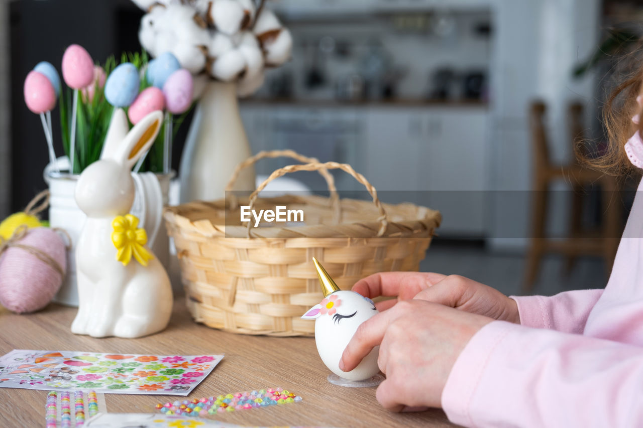 midsection of woman putting coin in jar on table