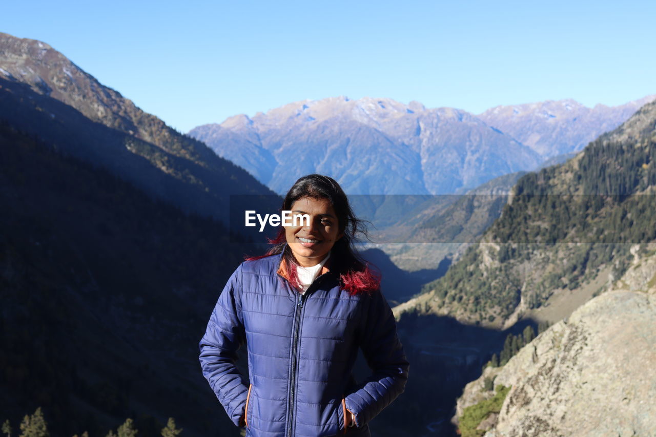 portrait of young man standing against mountains