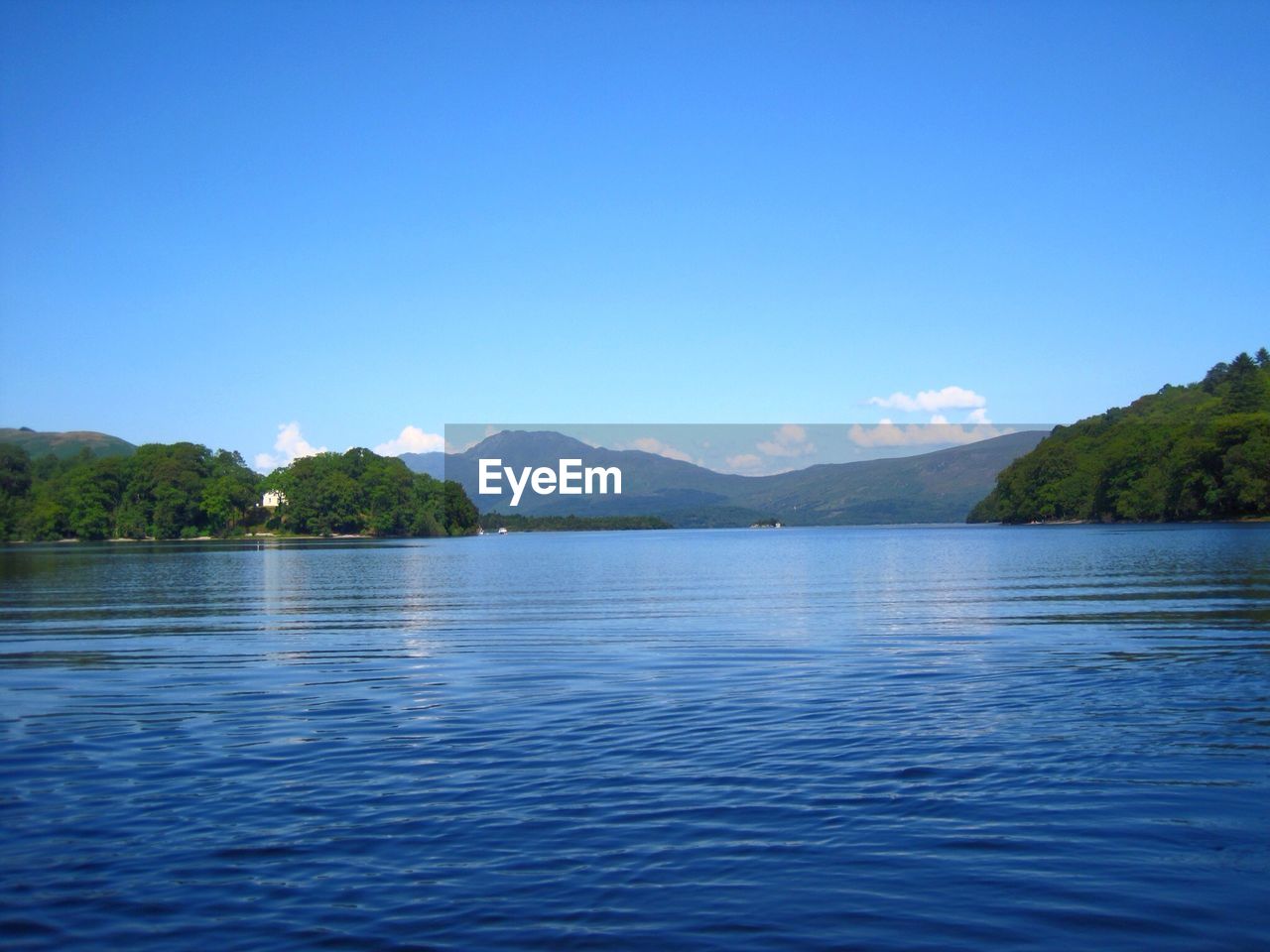 Scenic view of lake against clear blue sky