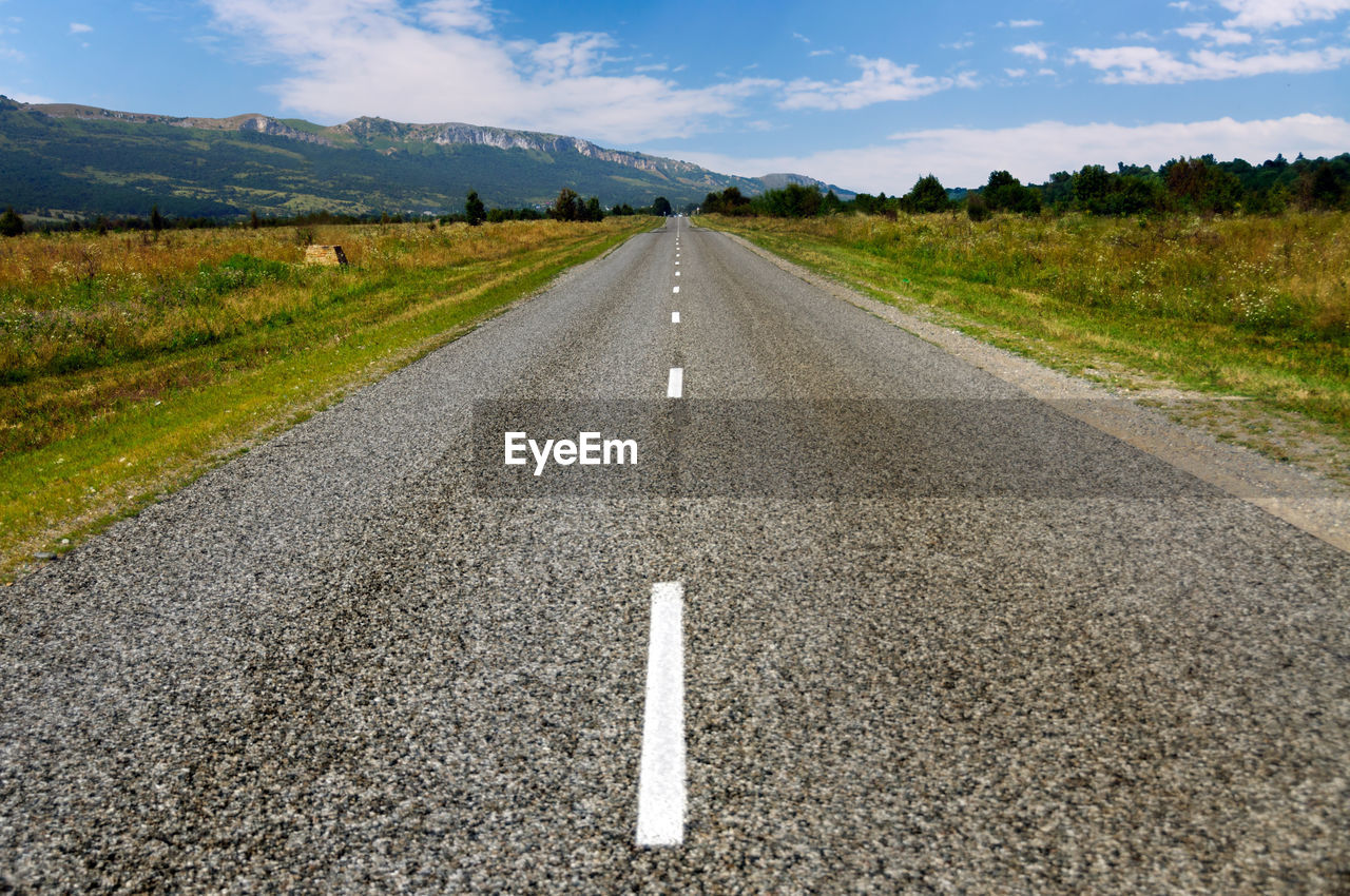 Road by landscape against sky