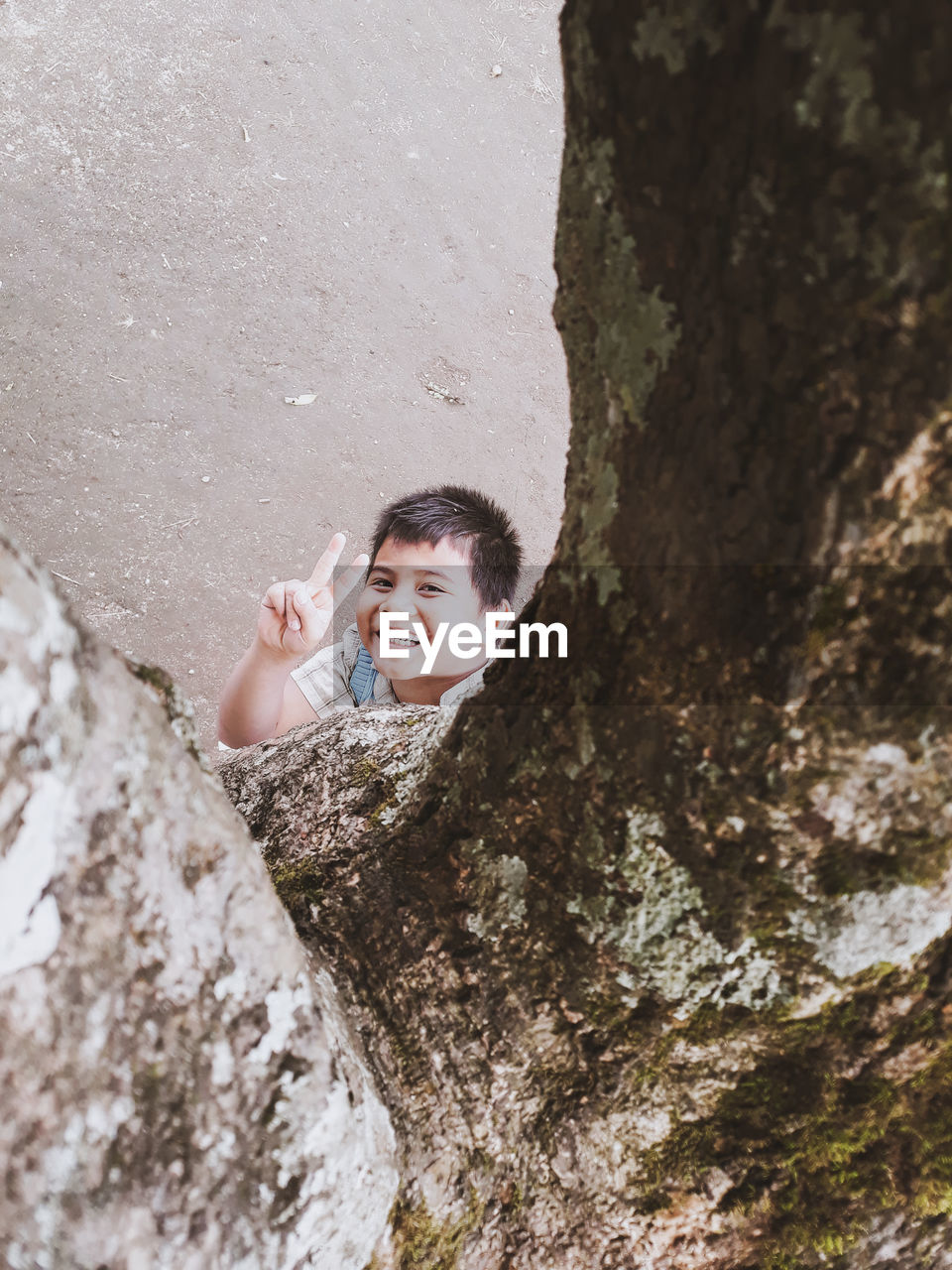 PORTRAIT OF HAPPY BOY ON ROCK