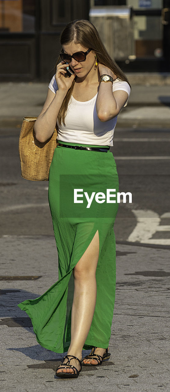 PORTRAIT OF A YOUNG WOMAN WEARING SUNGLASSES