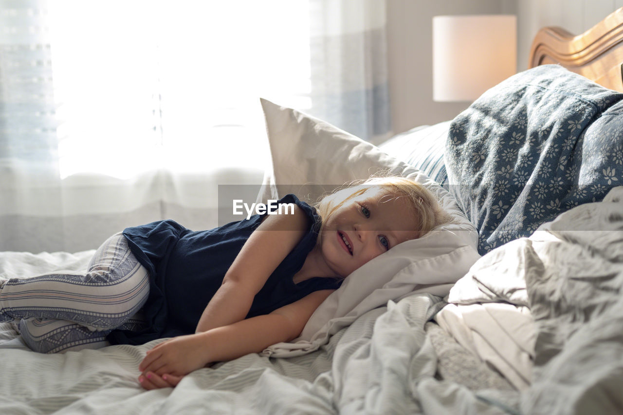 Portrait of girl lying on bed at home