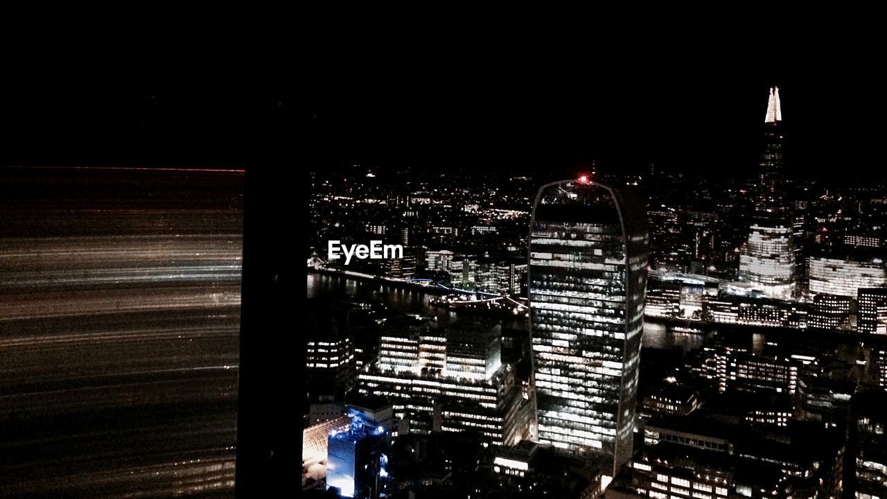 VIEW OF ILLUMINATED CITYSCAPE AT NIGHT