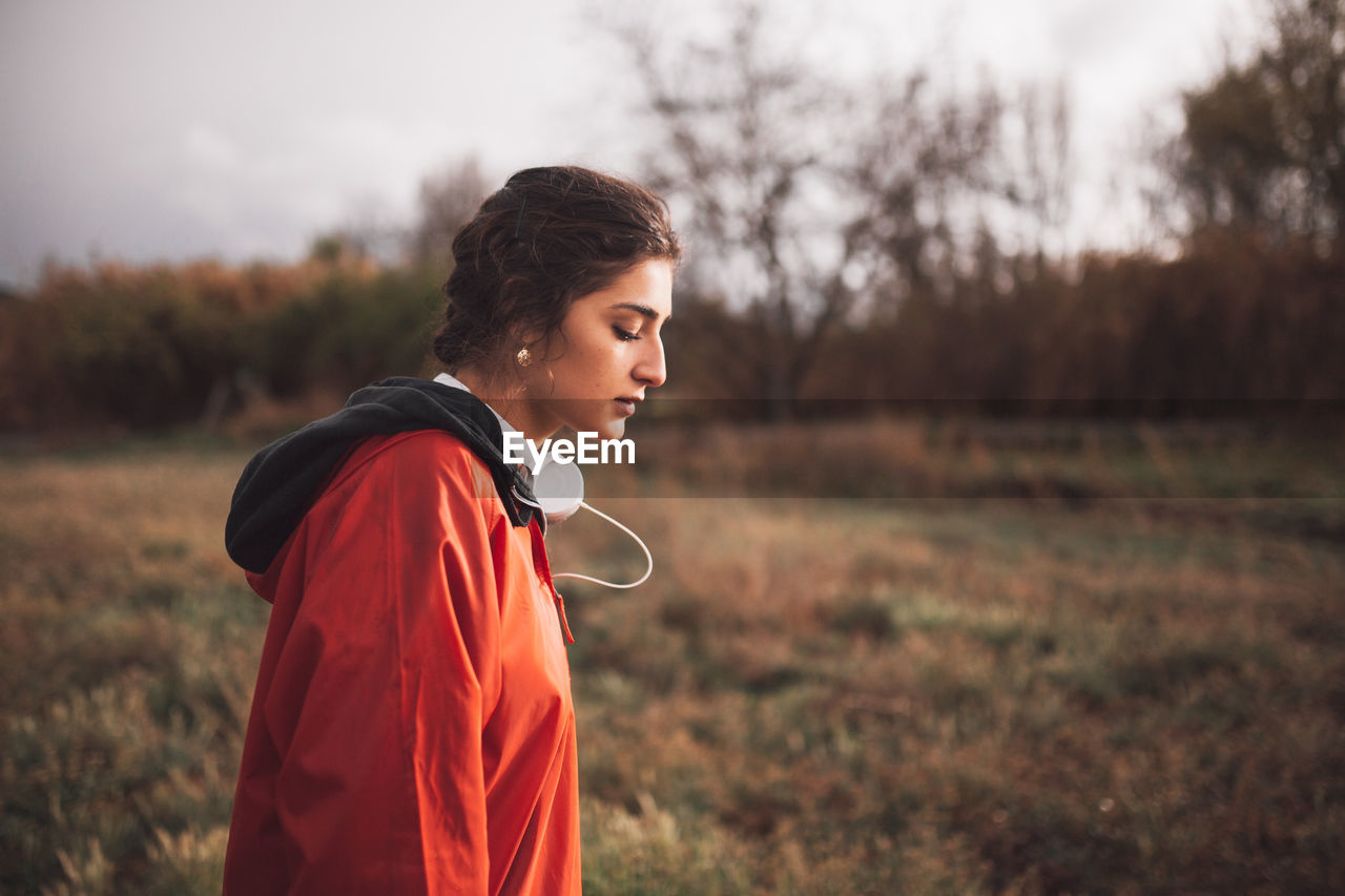 Young woman looking down while standing on land