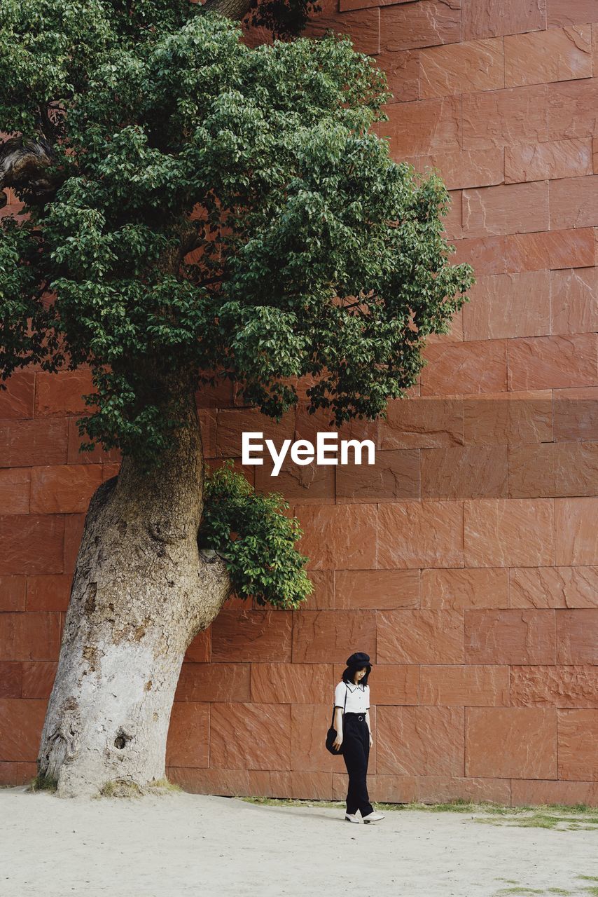 WOMAN STANDING AGAINST WALL