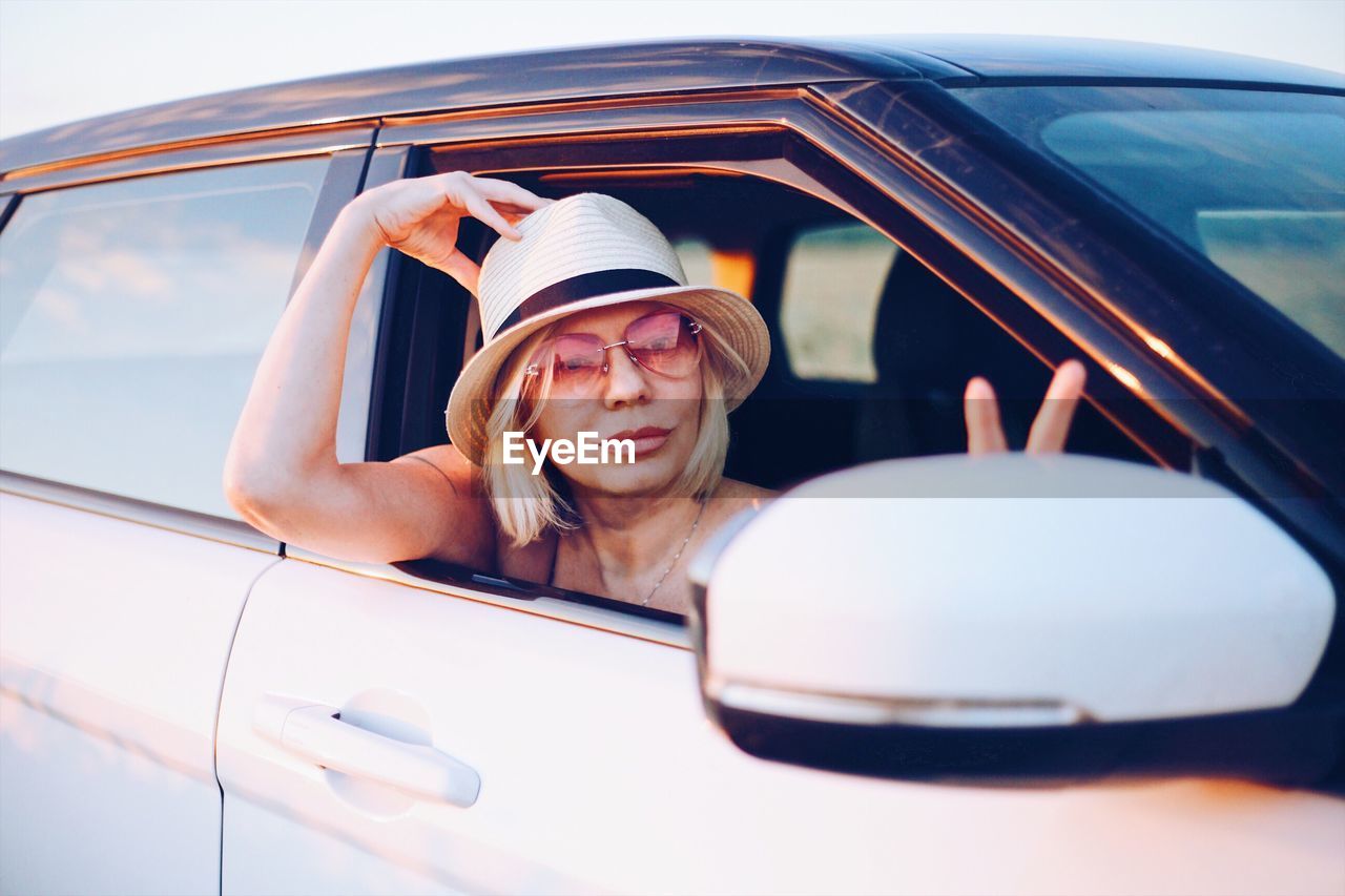 Portrait of smiling beautiful woman looking car window