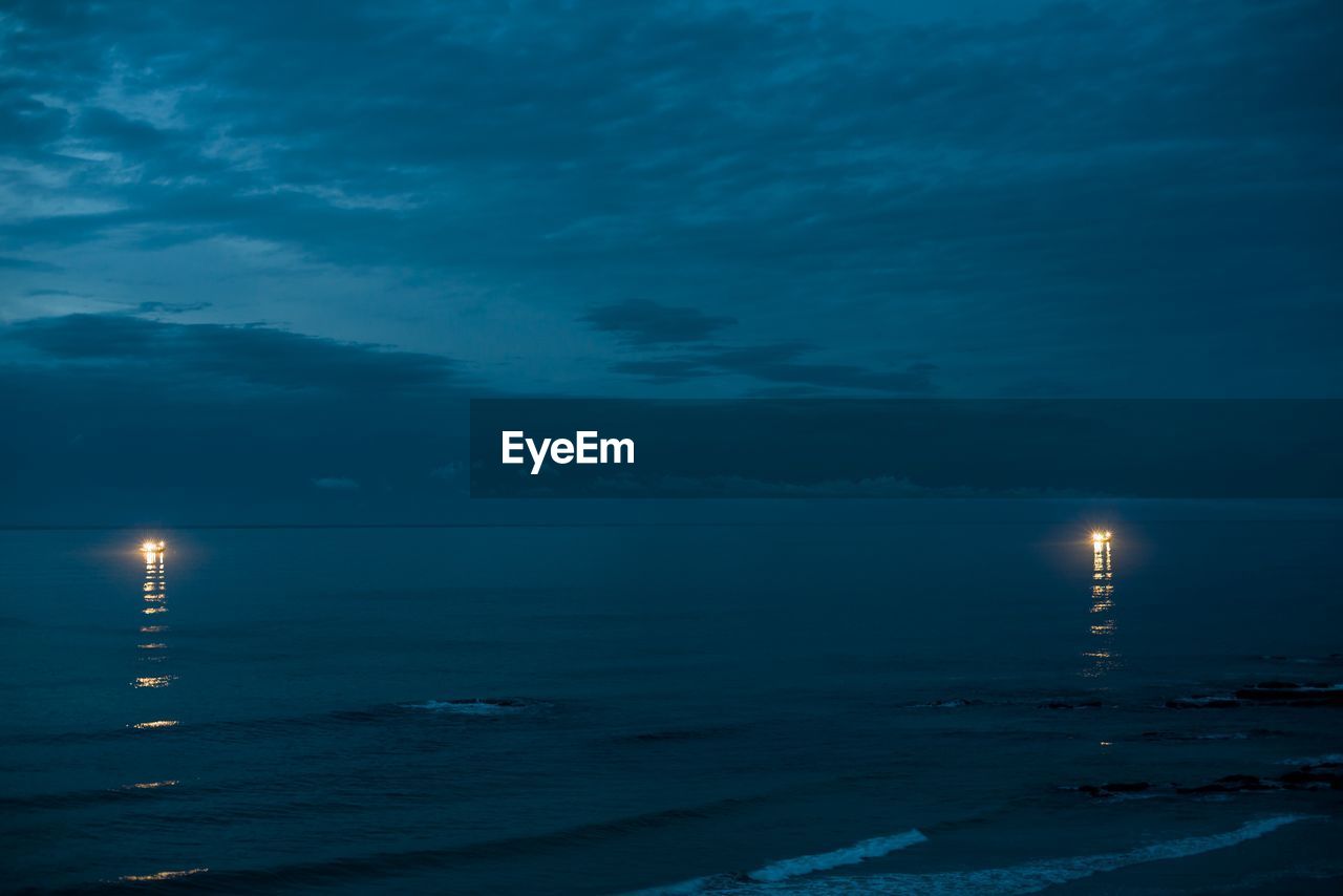 SCENIC VIEW OF SEA AGAINST BLUE SKY AT DUSK