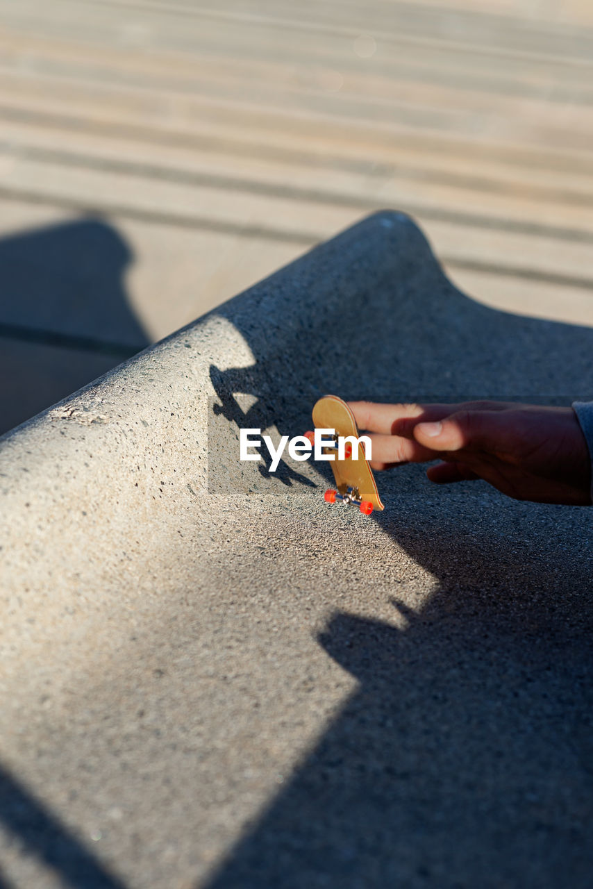 Riding a mini skateboard or fingerboard on outdoors ramp