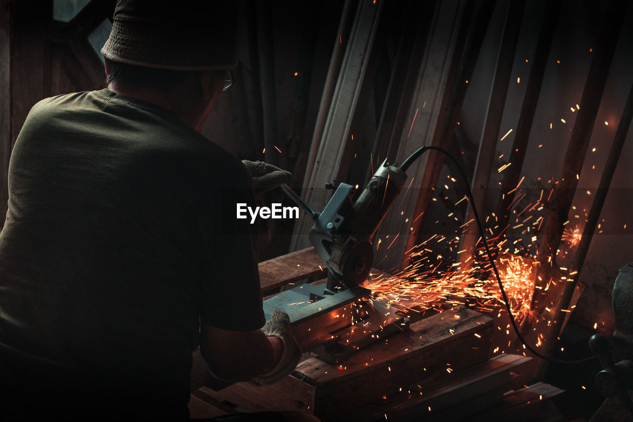 rear view of man welding in workshop