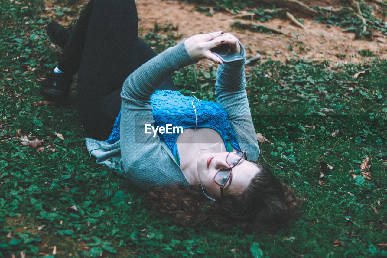 Portrait of young woman lying on grass