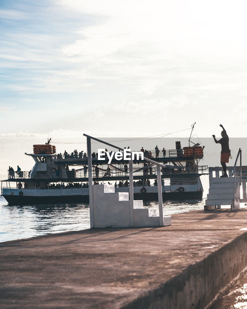 People on ferry sailing in sea against sky
