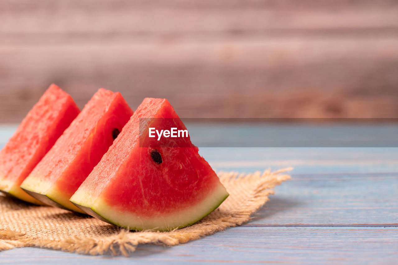 3 pieces of watermelon slices on the wooden table.