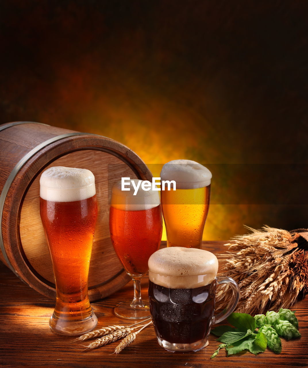 CLOSE-UP OF BEER GLASS ON TABLE AGAINST ORANGE