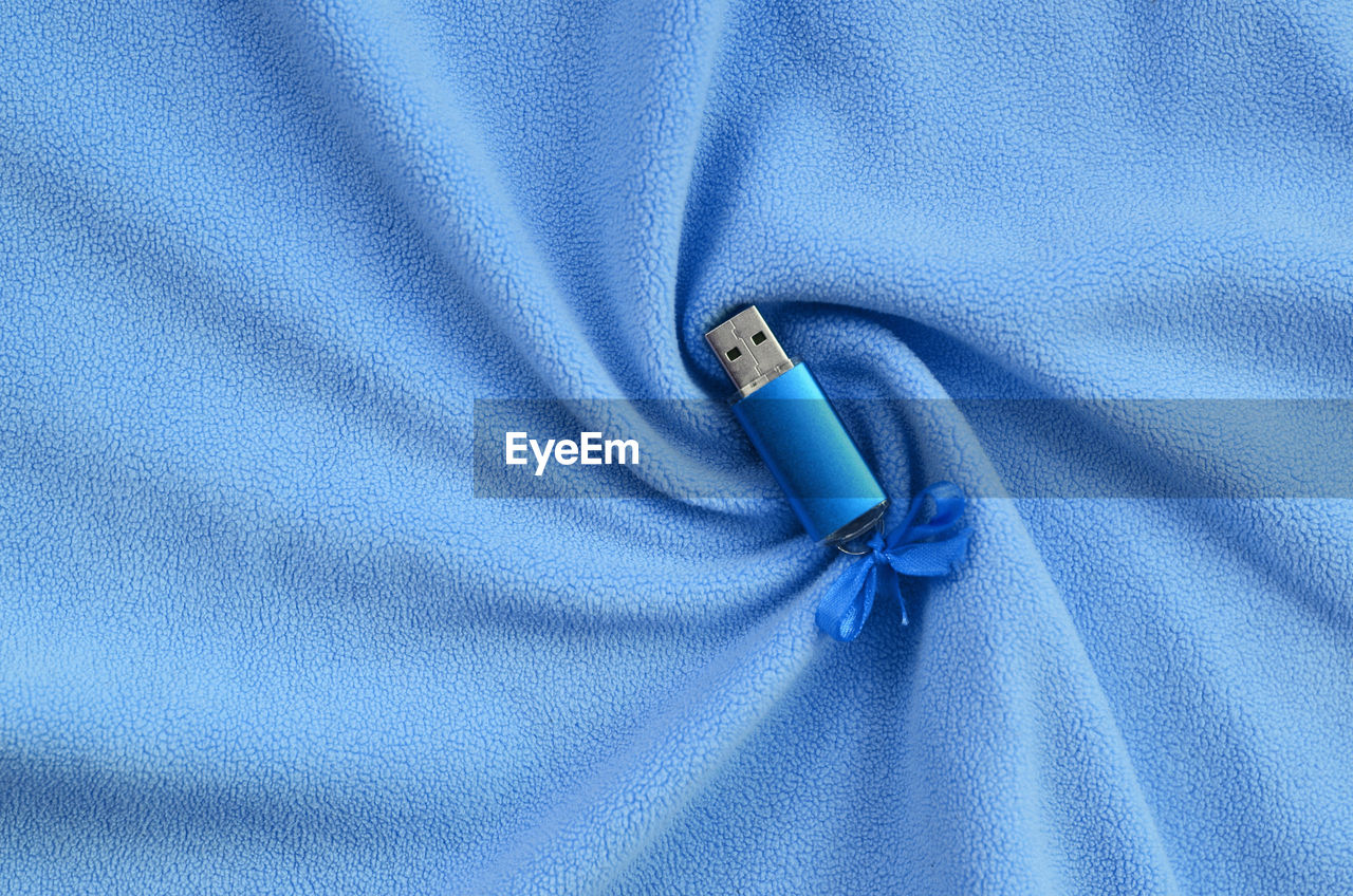 Full frame shot of blue usb stick on textile