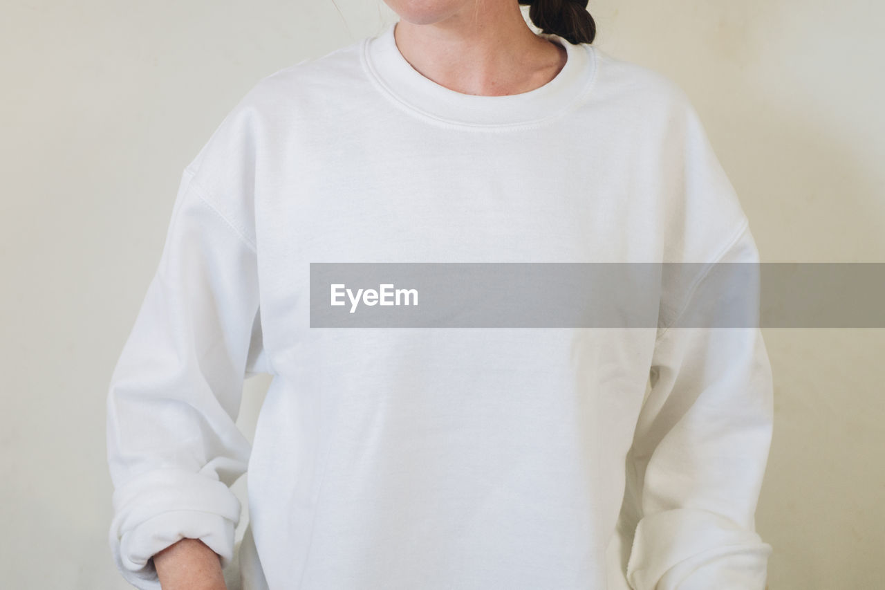 white, sleeve, one person, clothing, t-shirt, indoors, adult, casual clothing, waist up, standing, front view, studio shot, shirt, collar, pocket, long-sleeved t-shirt, midsection, button down shirt, copy space, women, portrait, men, outerwear, mature adult, blouse