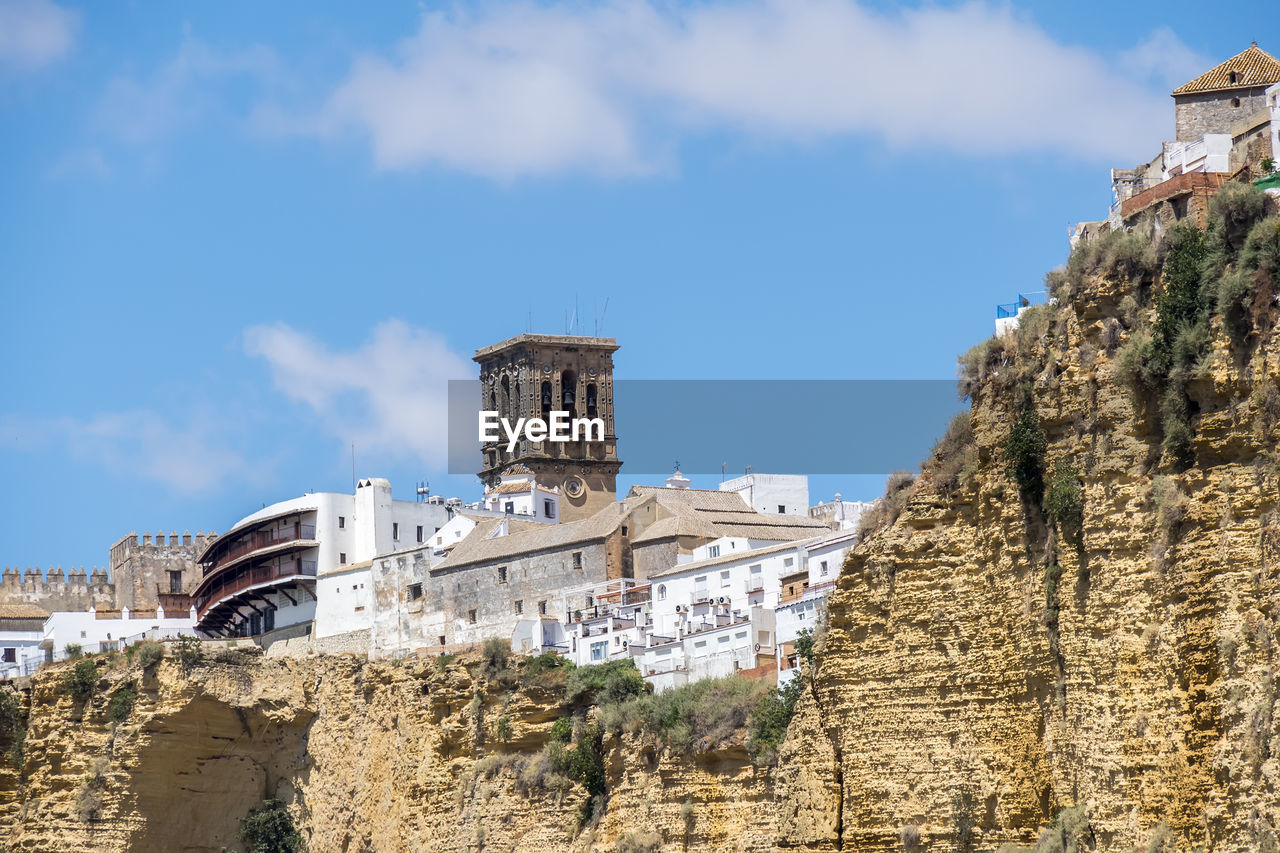 architecture, sky, built structure, landmark, history, fortification, building exterior, the past, tourism, vacation, travel destinations, ruins, nature, ancient history, cloud, travel, sea, building, day, ancient, land, coast, no people, fort, outdoors, castle, blue, town, religion, tower, wall, old, cliff, low angle view, city, rock