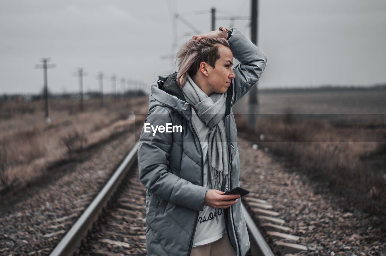 Young woman standing on railroad track