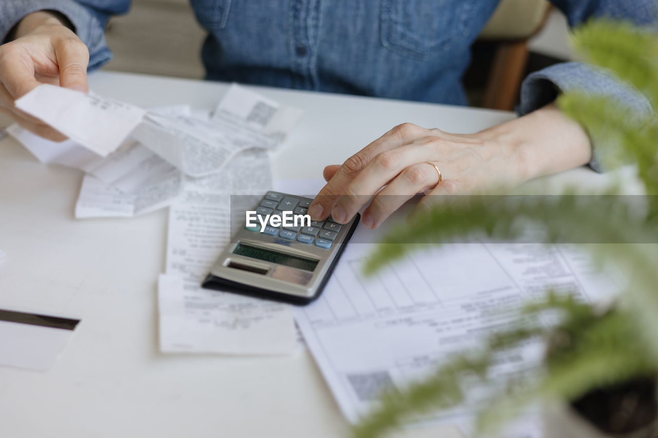 midsection of businessman using calculator