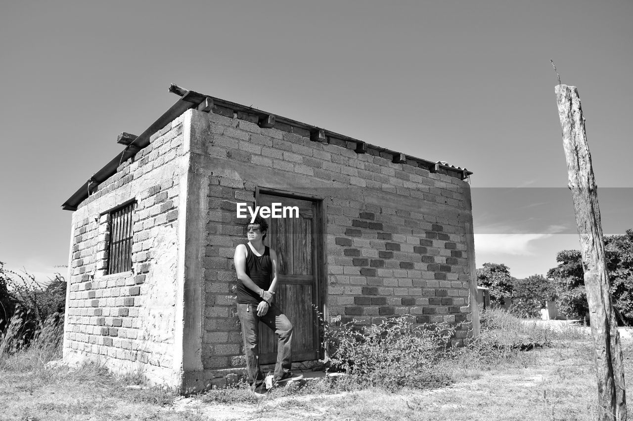 Man standing against house