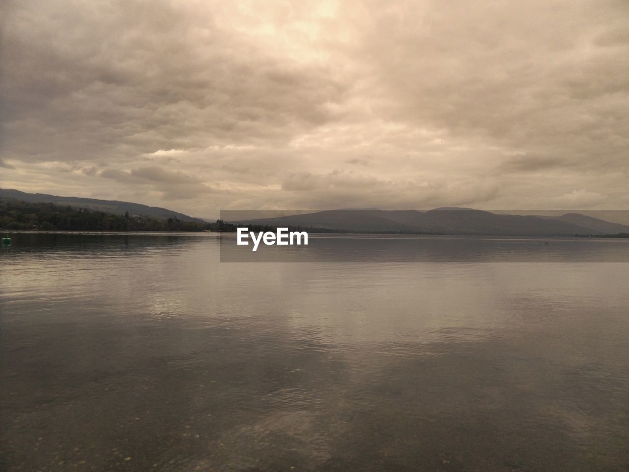 SCENIC VIEW OF LAKE AGAINST CLOUDY SKY