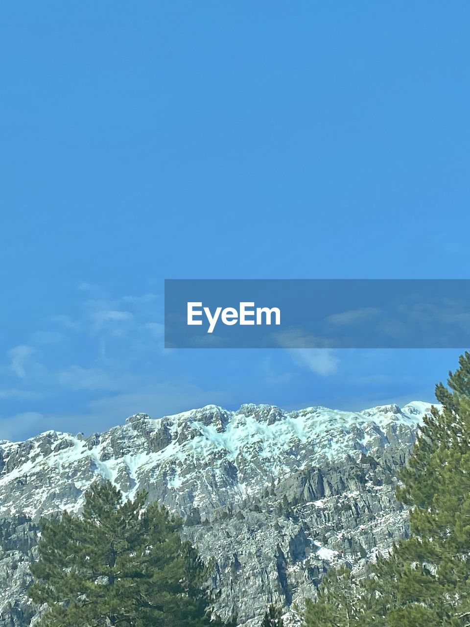 sky, mountain, beauty in nature, mountain range, scenics - nature, snow, plant, tree, nature, blue, winter, cloud, cold temperature, no people, day, environment, tranquility, tranquil scene, pine tree, low angle view, outdoors, landscape, non-urban scene, coniferous tree, land, pinaceae, copy space, ridge, idyllic, growth, forest