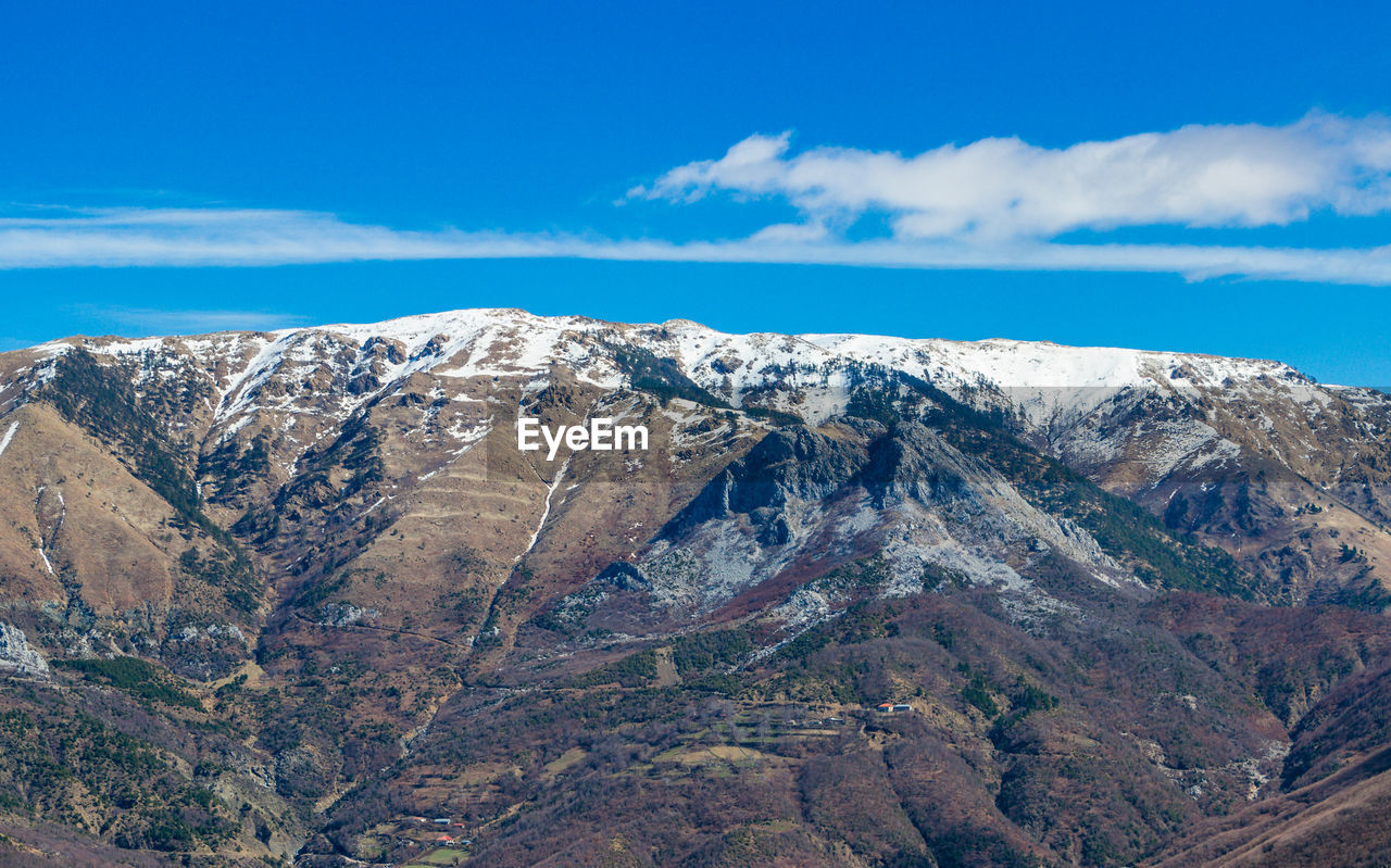 Scenic view of mountains against blue sky