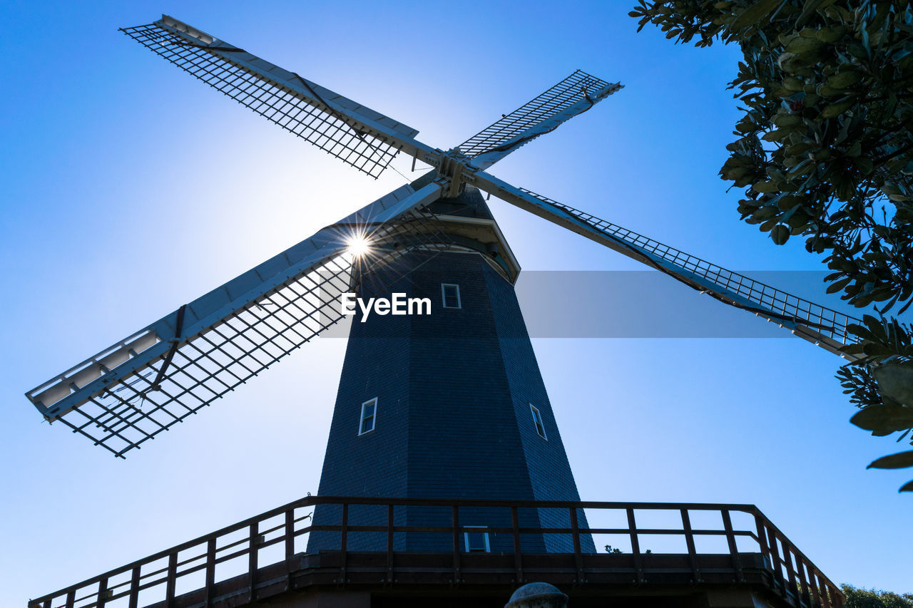 LOW ANGLE VIEW OF WINDMILL AGAINST CLEAR BLUE SKY