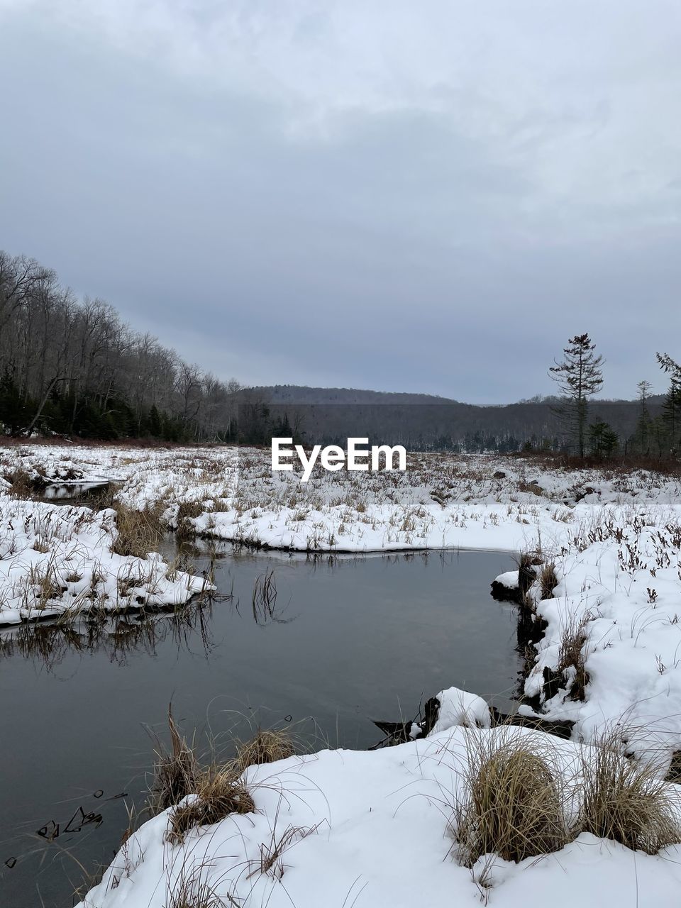 Scenic view of lake against sky during winter