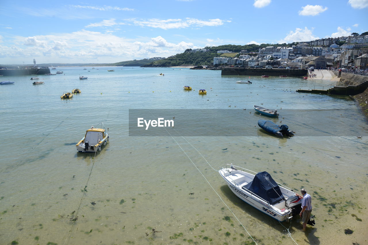 HIGH ANGLE VIEW OF BOATS MOORED ON SEA