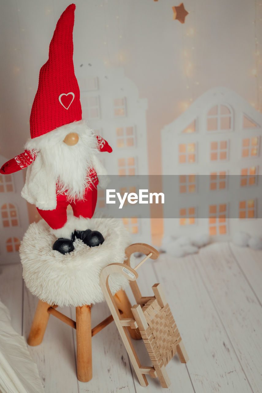 Close-up of christmas decoration santa claus on a chair and a toy sleigh