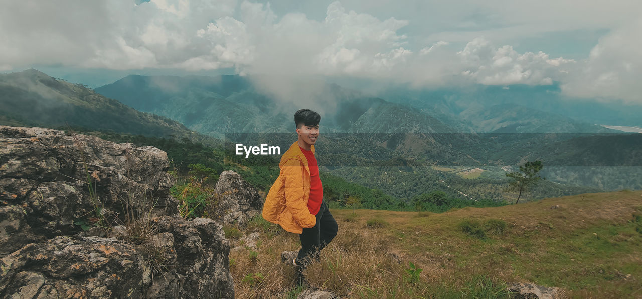 Man standing on mountain against sky