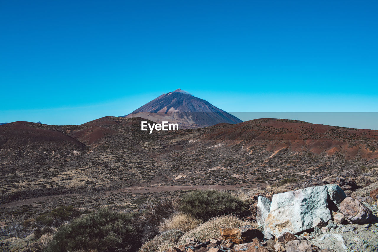 View of volcanic mountain against blue sky