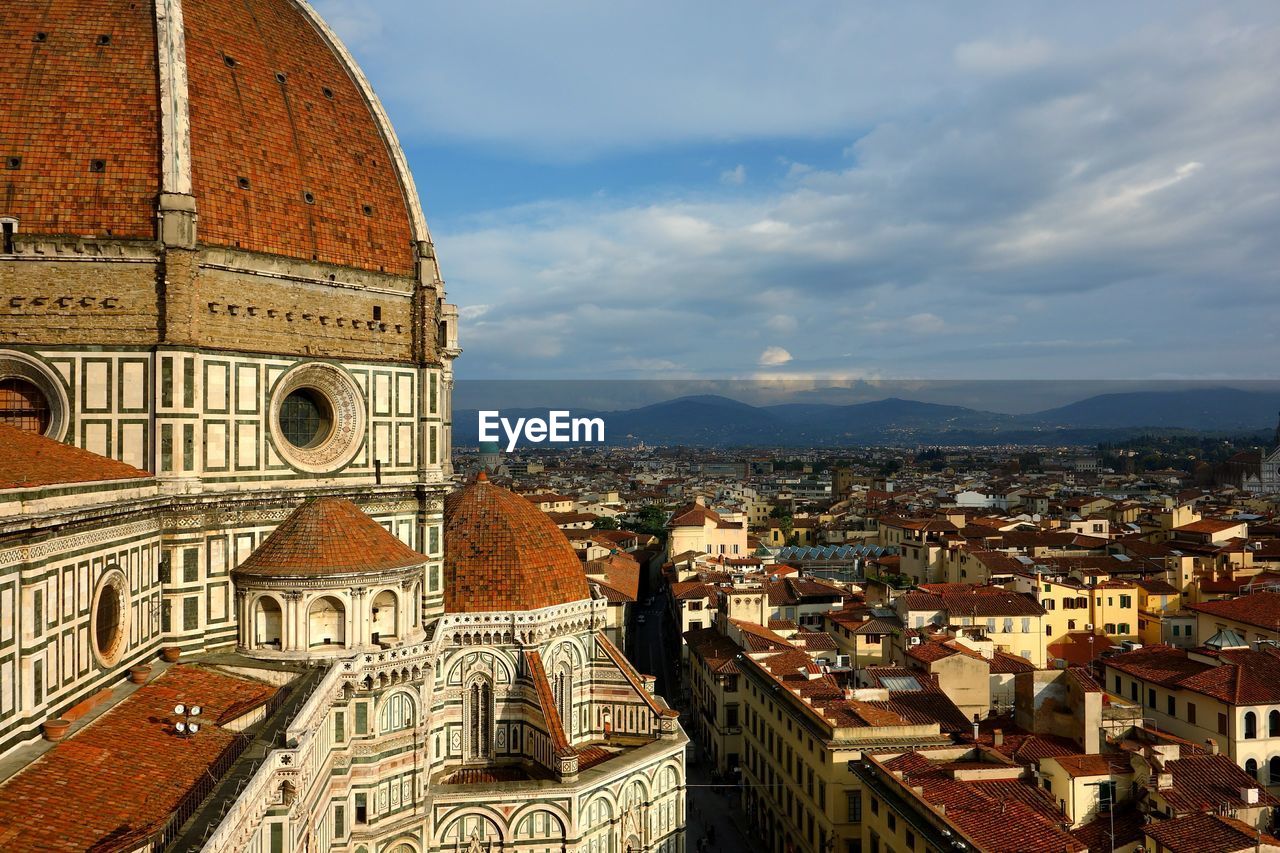 Florence cathedral in city against cloudy sky