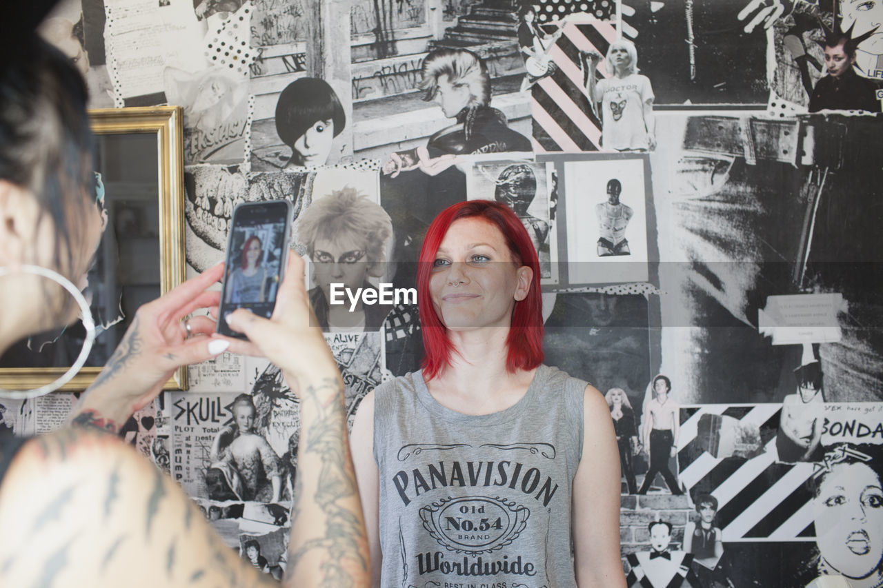 A hair dresser taking a photo of a customer.