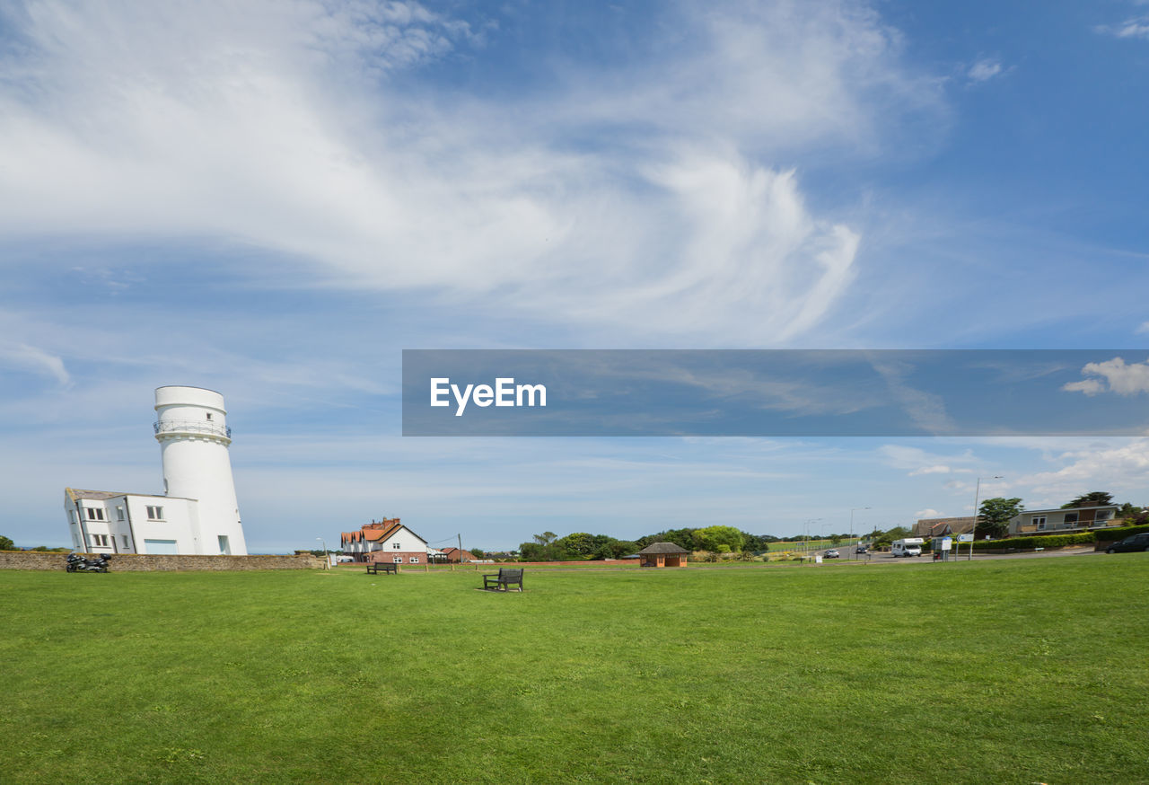 SCENIC VIEW OF FIELD BY LIGHTHOUSE AGAINST SKY