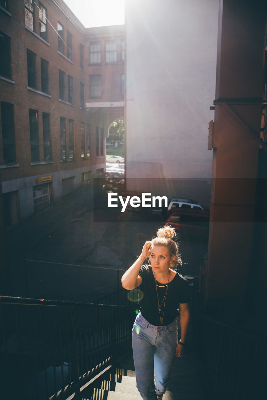 Young woman on walking on steps in city