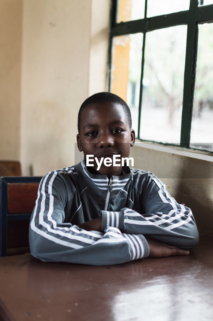 PORTRAIT OF BOY SITTING WITH TABLE