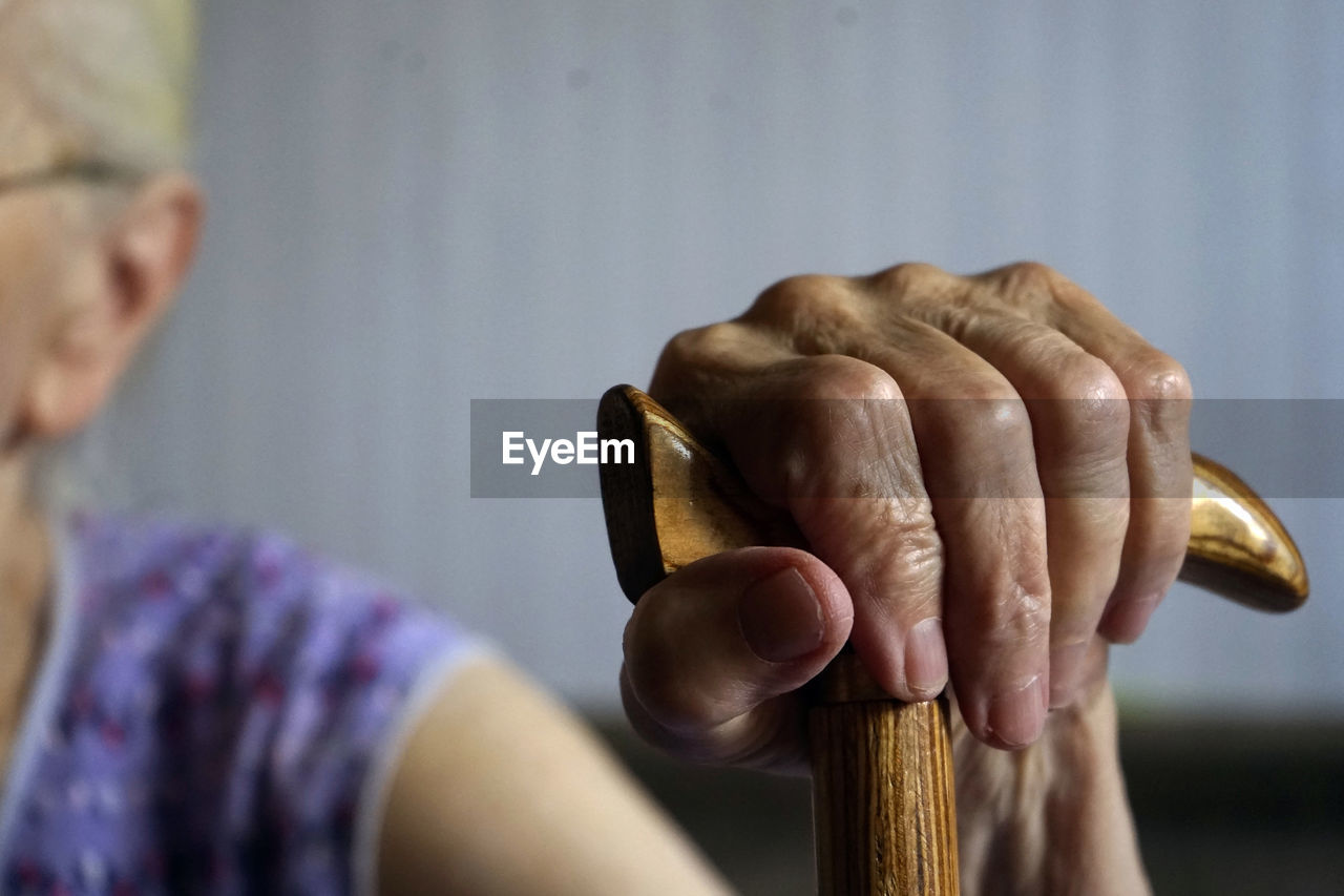 Close-up of senior woman holding walking cane