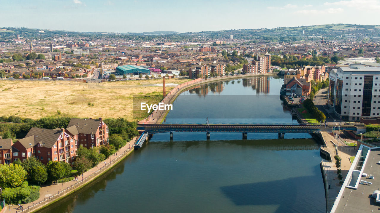 High angle view of river amidst buildings against sky