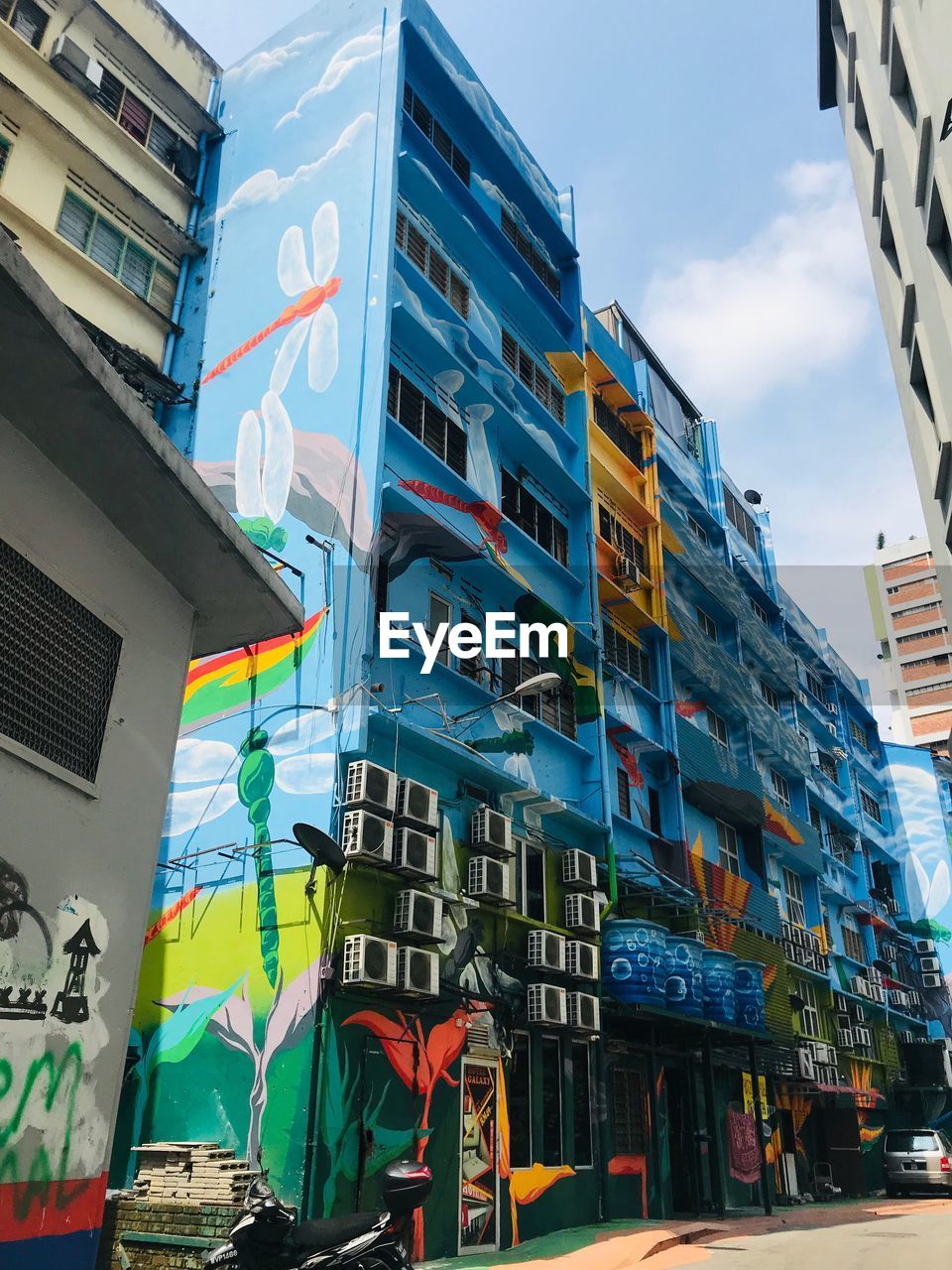 LOW ANGLE VIEW OF MULTI COLORED BUILDING AGAINST SKY